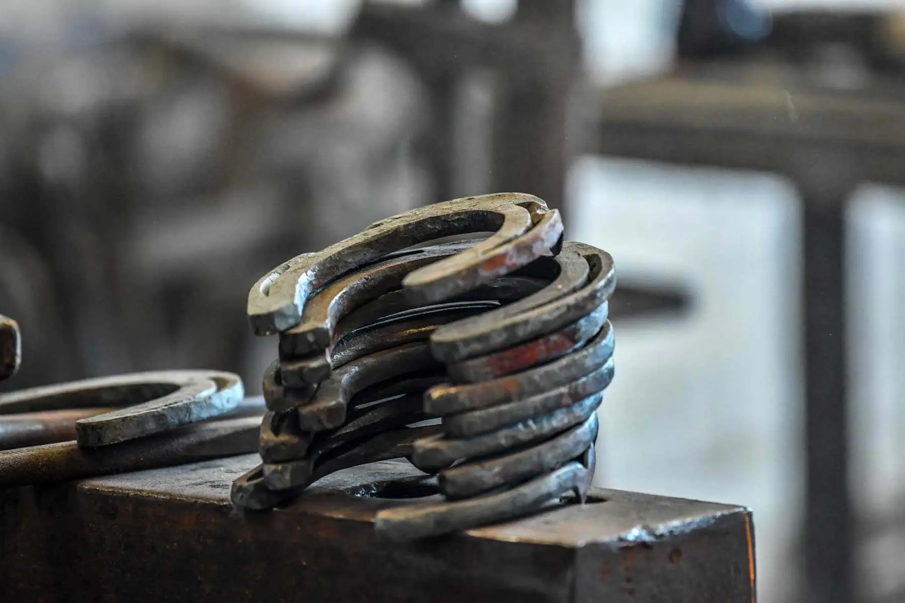 Stack of handmade horseshoes resting on the anvil, Hook Norton Farriers, Oxfordshire